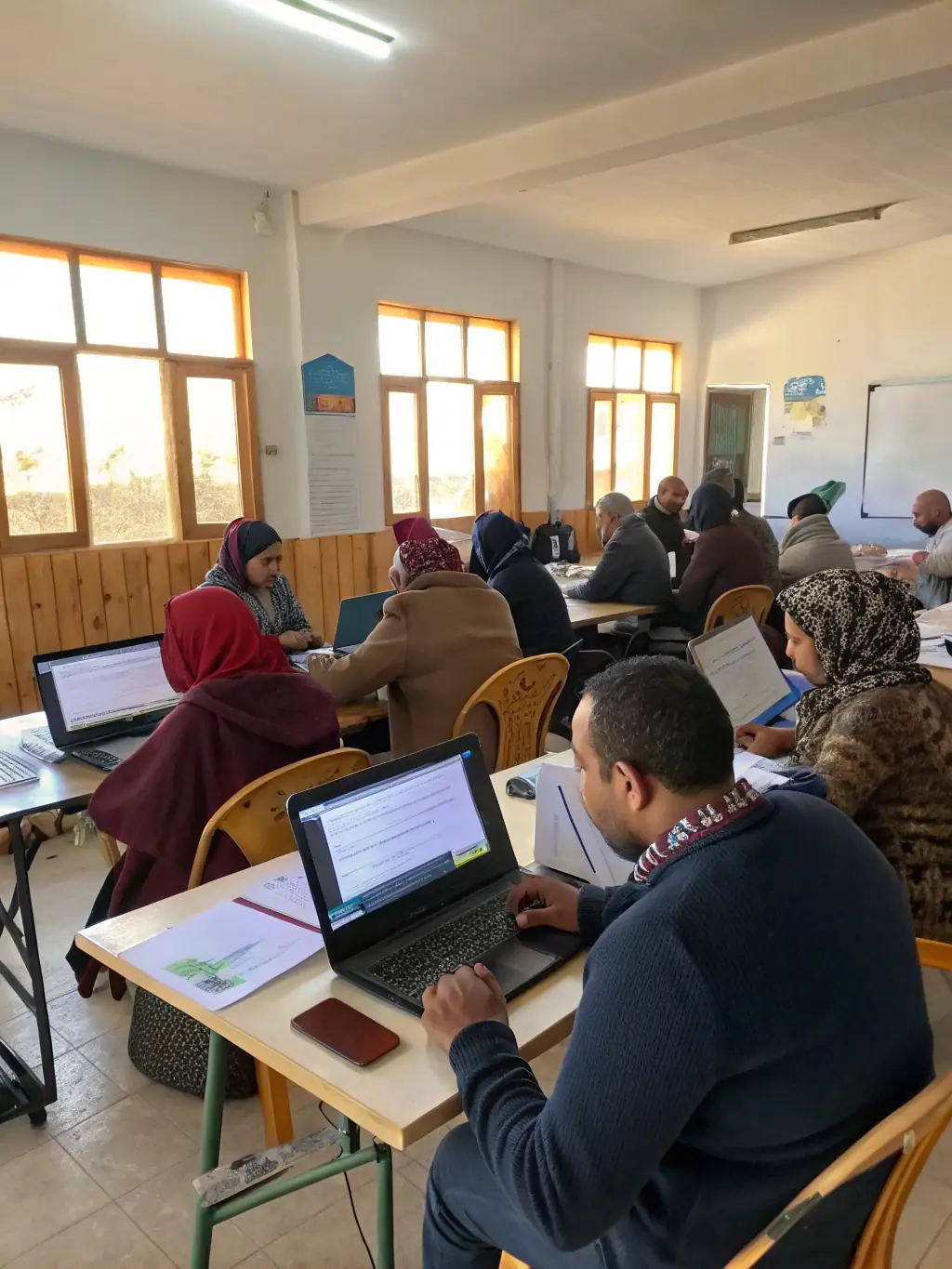 An image of a community workshop with participants engaging in digital media activities, illustrating ARANEA EDITIONS' educational and cultural programs.